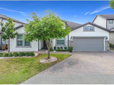 Charming home featuring a brick driveway, manicured lawn, and a two-car garage at 5647 Barletta Dr, St Cloud, FL 34771