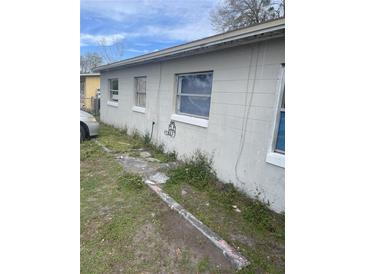 Side exterior view of a modest one-story house showing multiple windows at 5915 Colchester Dr, Orlando, FL 32812