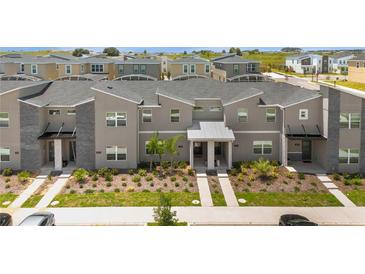 Contemporary townhouse with gray exterior, modern landscaping, and inviting entrance at 1106 Kingsbarn St, Davenport, FL 33896