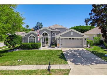 Charming single-story home featuring a well-manicured lawn, two-car garage, and neutral gray exterior at 124 Windsor Cresent St, Winter Springs, FL 32708