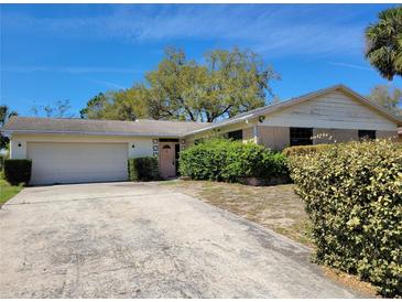 Charming single-story home with a two-car garage and mature landscaping at 1838 Windmill Dr, Orlando, FL 32818