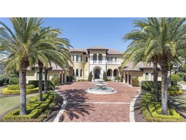 Stunning Mediterranean-style home featuring a fountain, lush landscaping, and a circular driveway at 3402 Cocard Ct, Windermere, FL 34786