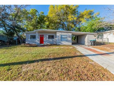 Charming single-story home featuring a bright red front door and a well-maintained front yard at 4906 Cortez Dr, Orlando, FL 32808
