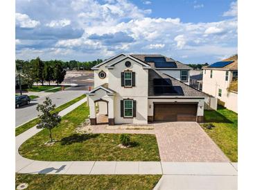 Beautiful two-story home with a well-manicured lawn, brick driveway, and solar panels at 5201 Villa Rosa Ave, St Cloud, FL 34771