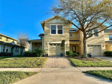 Charming two-story home featuring a well-manicured lawn, inviting walkway, and attached one car garage at 9843 Tivoli Villa Dr, Orlando, FL 32829