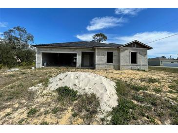 Image of a single-Gathering house with cinder blocks; garage and front door visible at 1201 Apopka Ln, Kissimmee, FL 34759