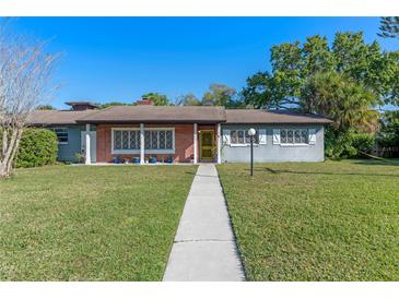 Charming single-story home with brick facade, walkway, and landscaped front yard under a clear, blue sky at 2805 Bongart Rd, Winter Park, FL 32792