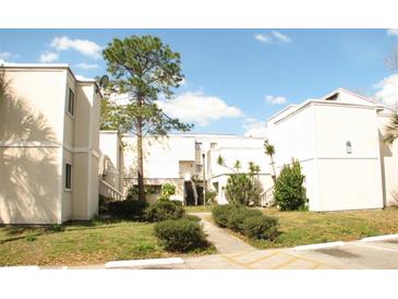 Attractive condo building with lush landscaping and a well-maintained pathway at 343 Scottsdale Sq # 343, Winter Park, FL 32792