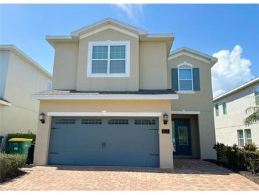 Two-story home with a brick driveway and an attached two-car garage at 7417 Marker Ave, Kissimmee, FL 34747
