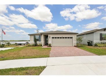 Charming single-story home featuring a two-car garage, brick driveway, and a well-maintained lawn at 800 Griffon Ave, Lake Alfred, FL 33850