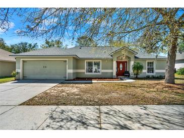 Charming single-story home featuring a two-car garage, manicured lawn, and inviting front porch at 1137 Stratton Ave, Groveland, FL 34736