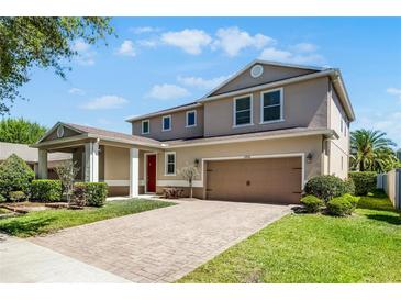 Beautiful two-story home featuring a two-car garage, brick driveway and lush landscaping at 11926 Verrazano Dr, Orlando, FL 32836