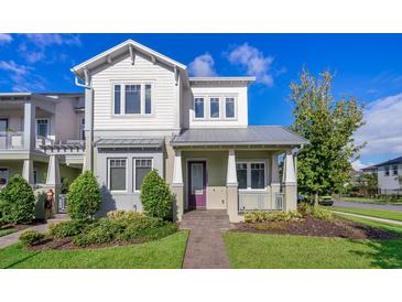 Charming two-story home featuring a quaint porch and landscaped front yard at 13852 Maskawa Ave, Orlando, FL 32827