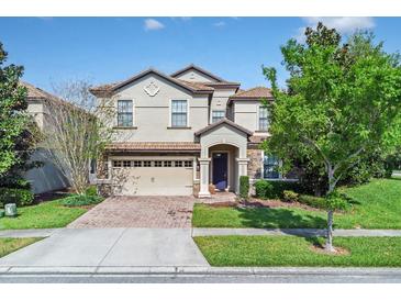 Charming two-story home featuring a well-manicured lawn, stone accents, and a two-car garage at 1400 Moon Valley Dr, Davenport, FL 33896