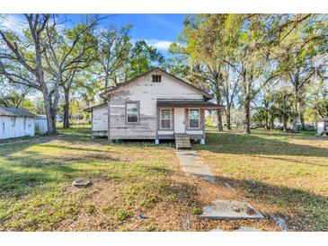 Exterior front view of a cozy home featuring a mature trees at 15 E Mohawk Street, Mascotte, FL 34753