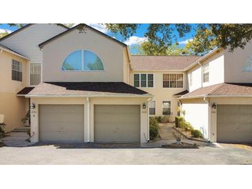 Inviting townhome featuring a two-car garage, neutral tones, and a well-maintained roof at 3038 Clubview Dr # Ge, Orlando, FL 32822