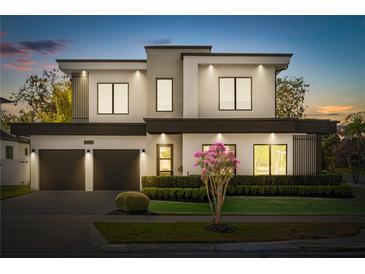 Contemporary two-story home with a two-car garage and manicured landscaping at twilight at 3322 Helen Ave, Orlando, FL 32804