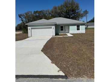 Charming single-story home featuring an attached two-car garage and freshly laid front yard at 4031 Sw 130Th Loop, Ocala, FL 34473