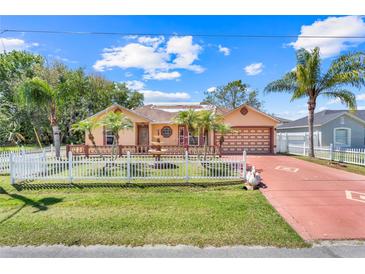Charming single-Gathering home with well-manicured lawn, fountain, palms, and a white picket fence at 449 Martigues Drive, Kissimmee, FL 34759