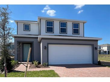 Charming two-story home featuring a two-car garage and a welcoming front entrance on a beautiful, sunny day at 7028 Rolling Leaf Rd, Groveland, FL 34736