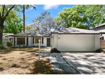 Charming single-story home boasts a well-manicured lawn, mature trees, and an attached two-car garage at 942 Cinnamon Ct, Altamonte Springs, FL 32714