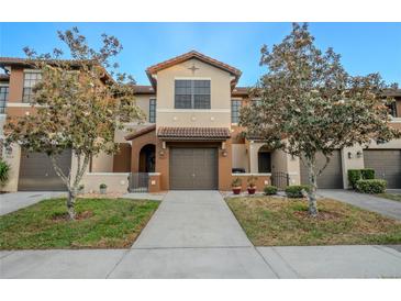 Charming townhome featuring a two-car garage and well-manicured landscaping for a welcoming curb appeal at 9620 Doris Ln, Orlando, FL 32829