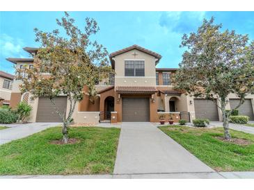 Charming townhome showcasing a well-manicured lawn and neutral-toned exterior, complemented by lovely trees at 9620 Doris Ln, Orlando, FL 32829