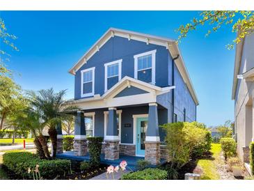 Charming two-story home with a welcoming porch, well-manicured landscaping, and a bright blue exterior at 11880 Sonnet Ave, Orlando, FL 32832