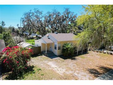 Quaint single-story home featuring lush trees, and a charming front porch, perfect for enjoying the outdoors at 1503 Holly Rd, Lakeland, FL 33801