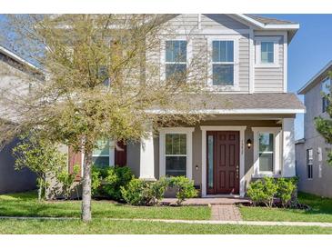 Charming two-story home with a well-maintained lawn and inviting front porch at 15837 Sweet Lemon Way, Winter Garden, FL 34787