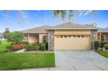 Charming single-story home with stone accents, manicured lawn, and well-kept landscaping at 253 Lake Cassidy Dr, Kissimmee, FL 34759
