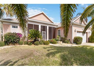 Charming single-story home featuring a screened porch, lush landscaping, and a well-maintained lawn at 4724 Sable Ridge Ct, Leesburg, FL 34748