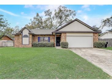 Charming single-story brick home with a well-manicured lawn and two-car garage at 5444 Lighthouse Rd, Orlando, FL 32808