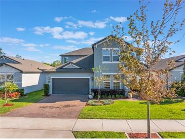 Charming two-story home featuring a well-manicured lawn, brick driveway, and attached two-car garage at 753 Daybreak Pl, Longwood, FL 32750