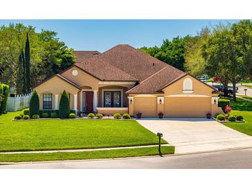 Charming single-story home featuring a well-manicured lawn, a two-car garage, and a classic, neutral color palette at 755 Country Charm Cir, Oviedo, FL 32765