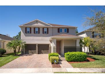 Charming two-story home featuring a brick-paved driveway, a three-car garage and well-maintained landscaping at 8066 Bowery Dr, Winter Garden, FL 34787