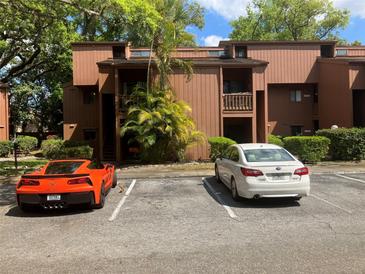 Exterior of a multi-story condo featuring parking, landscaping, and trees, providing a welcoming curb appeal at 1068 E Michigan St # A, Orlando, FL 32806