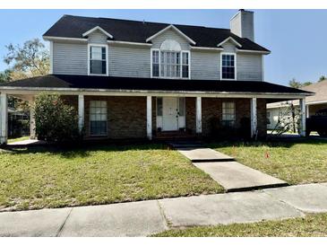 Charming two-story home with a inviting front porch, showcasing its classic architectural design at 1233 Hancock Cir, St Cloud, FL 34769