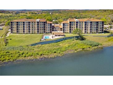 Scenic aerial view of lakeside condominiums with lush landscaping and a tranquil water view at 16300 County Road 455 # 401, Montverde, FL 34756