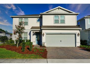Charming two-story home with a well-maintained lawn, brick driveway, and an attached two-car garage at 2313 Ivy Harvest Pl, Oviedo, FL 32765