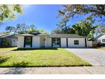 Charming one story home featuring a well-manicured lawn and a paved driveway at 2360 Justy Way, Orlando, FL 32817
