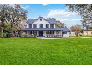 Charming two-story home with a sprawling lawn, welcoming front porch, and classic black shutters at 2365 Eagle Trace Dr, Kissimmee, FL 34746