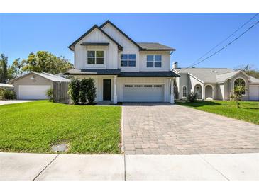 Charming two-story home with a modern design, manicured lawn, and brick paver driveway at 705 Baffie Ave, Winter Park, FL 32789