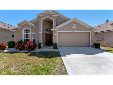 Charming home featuring a two-car garage, manicured lawn, and front garden at 782 Seneca Meadows Rd, Winter Springs, FL 32708