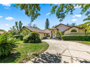 Charming single-story home with a well-manicured lawn, mature landscaping, and a welcoming circular driveway at 10116 Pointview Ct, Orlando, FL 32836
