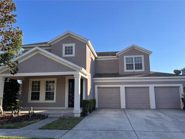 Charming home with a well-maintained lawn, three-car garage, and attractive curb appeal on a sunny day at 13422 Exbury Ln, Windermere, FL 34786
