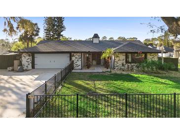 Charming single-story home featuring a well-manicured lawn and a fenced yard at 1475 Kettledrum Trl, Deltona, FL 32725