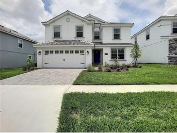 Charming two-story home with a well-manicured lawn, paved driveway and a two car garage at 1673 Moon Valley Dr, Davenport, FL 33896