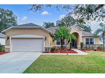 Charming single-story home featuring a manicured lawn, complemented by a two-car garage at 1913 Lazy Oaks Loop, St Cloud, FL 34771