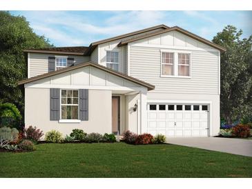 Charming two-story home with white siding, complemented by a manicured lawn and inviting curb appeal at 313 Castle Dr, Lake Alfred, FL 33850